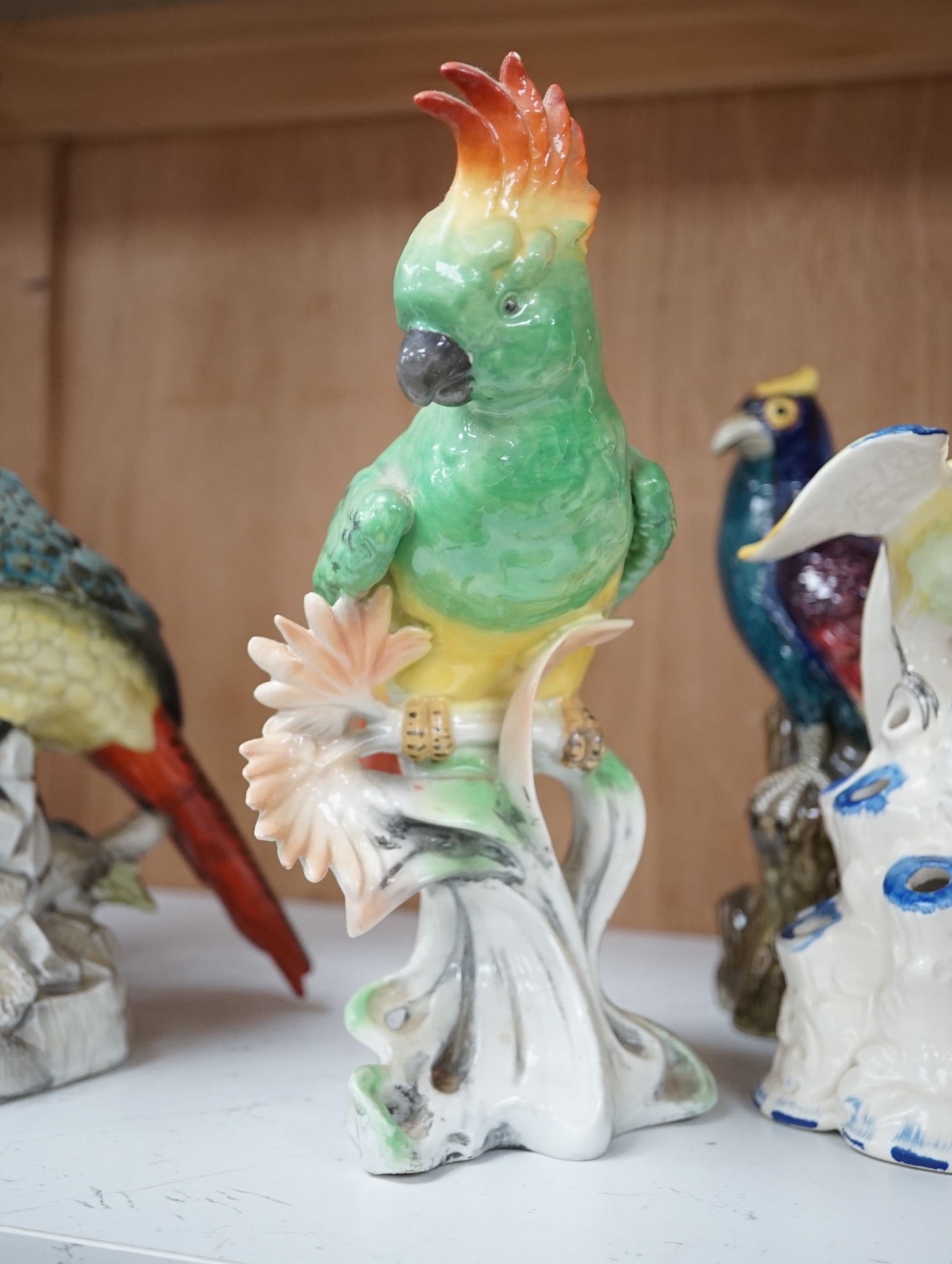 A group of twelve ceramic parrots including one by S Hancock & Sons, largest 24cm high. Condition - mostly good